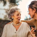 Relationship Influencer - Joyful adult daughter greeting happy surprised senior mother in garden