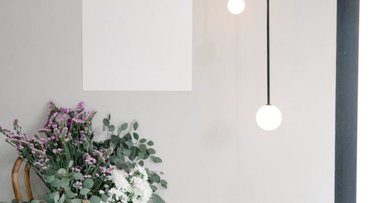 Ad Copy - Bouquet of fresh wildflowers in wicker basket placed near wall with white mockup