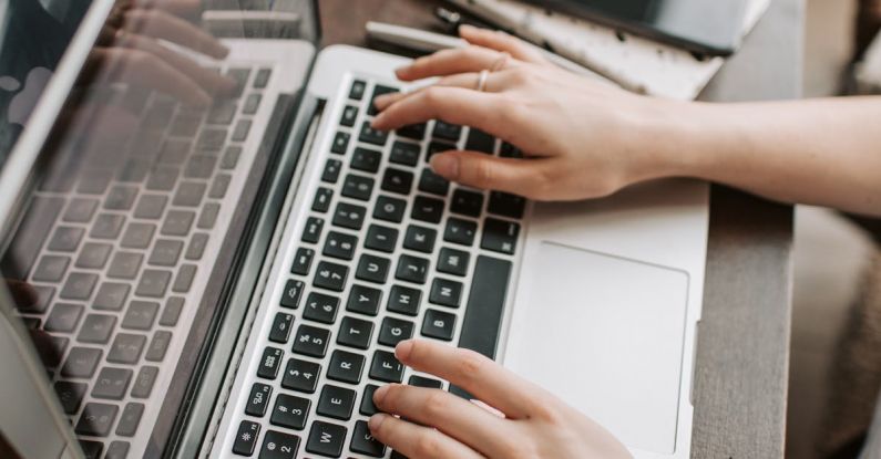 Keyword Search - From above of unrecognizable woman sitting at table and typing on keyboard of computer during remote work in modern workspace