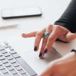 Local Seo - Crop female using touchpad on laptop in office