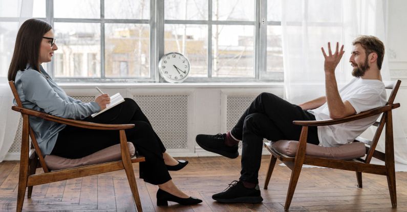 Analytics Social - Person in Black Pants and Black Shoes Sitting on Brown Wooden Chair