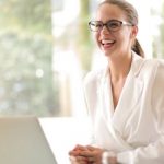 Employee Advocacy - Laughing businesswoman working in office with laptop